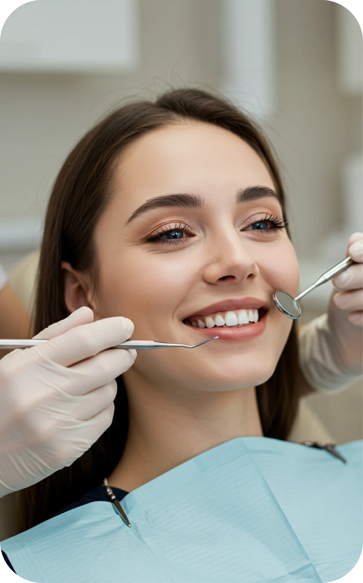 smiling woman having teeth checked with dental tools